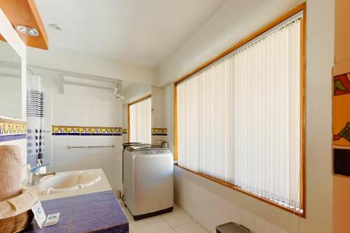 a bathroom with a sink and a refrigerator and a window at Sumaq Sisa Home & Loft in Cusco