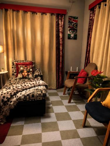 a bedroom with a bed and a checkered floor at Toby's Apartment in Mbabane