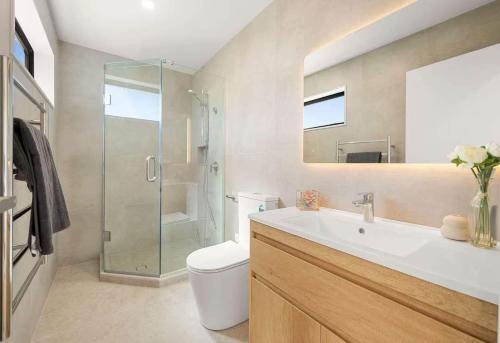 a bathroom with a toilet and a sink and a shower at Duo Duo in Auckland