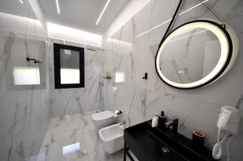 a white bathroom with a mirror and a sink at Lavéa Villa in Draç