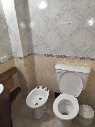 a bathroom with a white toilet and a sink at Hotel Argentina in Mina Clavero