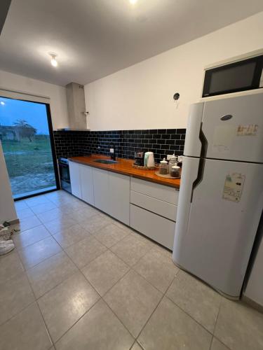 a kitchen with a white refrigerator and a window at Casa Marti in Los Reartes