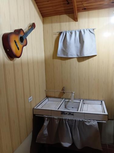a kitchen with a sink and a guitar on the wall at Maye WOOD APT in Uvita