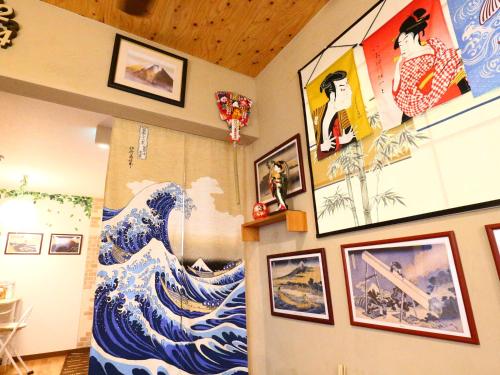 a room with a painting of a wave on the wall at ホステル富士山 結 in Fujiyoshida