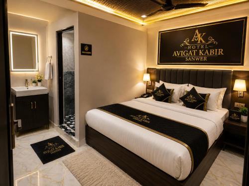 a bedroom with a king sized bed and a bathroom at Hotel avigat kabir sanwer in Indore
