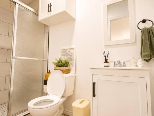 a white bathroom with a toilet and a shower at Tiny Studio in Orange Garden in Los Angeles