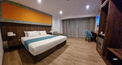 a hotel room with a bed and a television at Hanaqua Cusco Hotel in Cusco