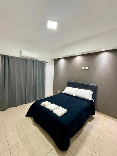 a bedroom with a blue bed with towels on it at Serena Suites in Ezeiza