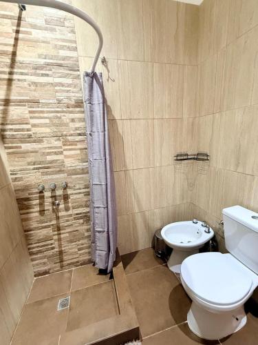 a bathroom with a toilet and a shower at Serena Suites in Ezeiza
