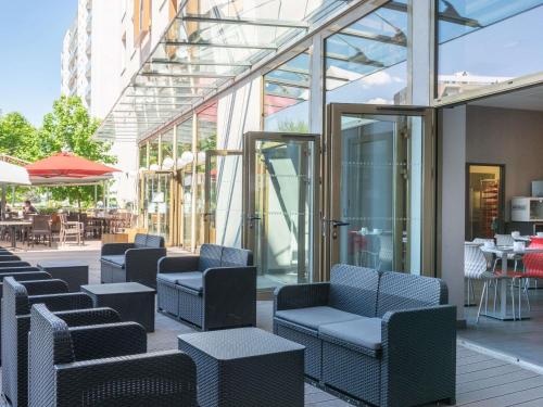 a patio with chairs and tables in a building at Adagio Access Grenoble Université in Saint-Martin-dʼHères