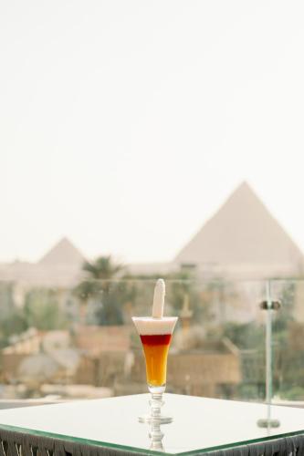 a candle in a glass sitting on top of a table at Irit pyramids inn in Cairo
