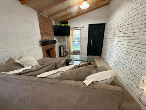 a living room with a couch and a brick wall at Descanso Cuchilla Alta in Cuchilla Alta
