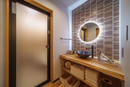 a bathroom with a sink and a mirror at 別府の宿 結 -Yui- in Beppu