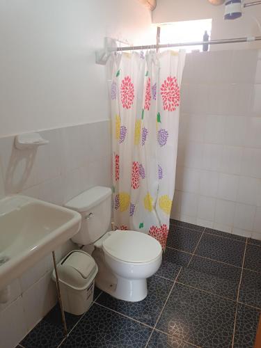a bathroom with a toilet and a shower curtain at Refugio tierra viva in Cusco