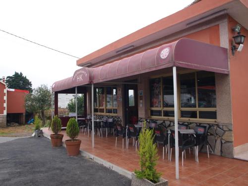 ein Restaurant mit Tischen und Stühlen außerhalb des Restaurants in der Unterkunft Pensión HK in A Angueira de Suso