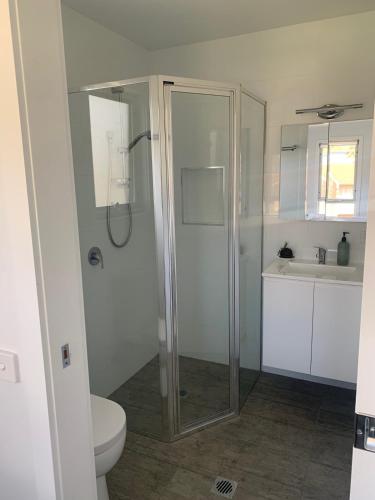 a bathroom with a shower and a toilet and a sink at Kuruwa in Tathra