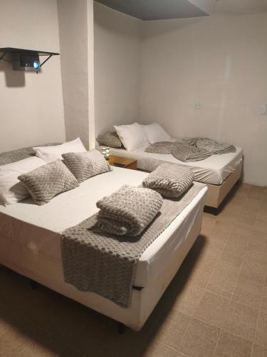 three beds sitting in a room with at Suíte Completa com Tela de Cinema in Garanhuns