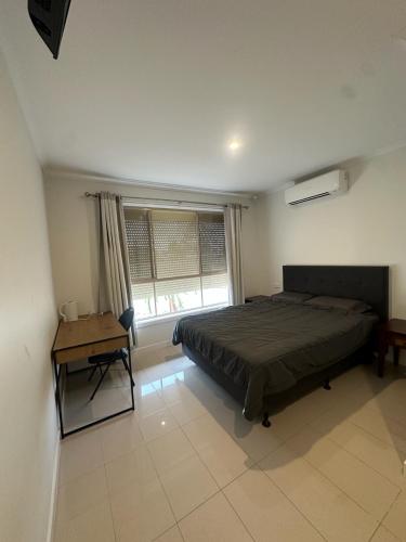 a bedroom with a bed and a desk and a window at Guest Room in Joan in St Albans