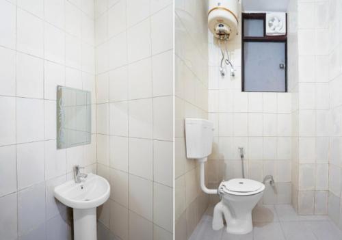 a white bathroom with a toilet and a sink at Shivik stays in Gurgaon