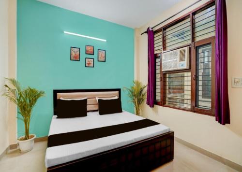 a bedroom with a large bed with a blue wall at Shivik stays in Gurgaon