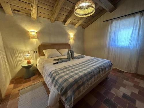 a bedroom with a large bed with a checkered blanket at La landaise in Commensacq