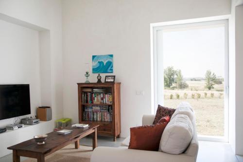 a living room with a couch and a table and a tv at Monte Da Azarujinha in Azaruja