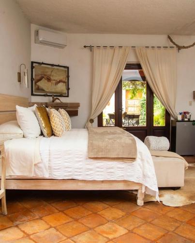 a bedroom with a large white bed and a window at Tres Fuentes Hotel Boutique in San Miguel de Allende
