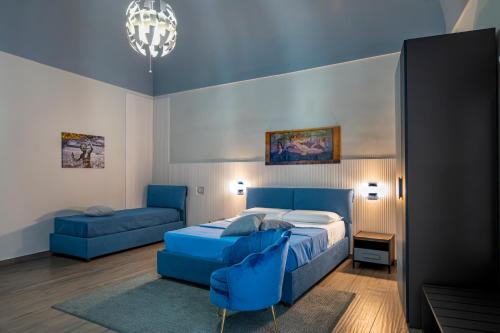 a bedroom with a blue bed and a blue couch at Domus Alma Pompei in Pompei