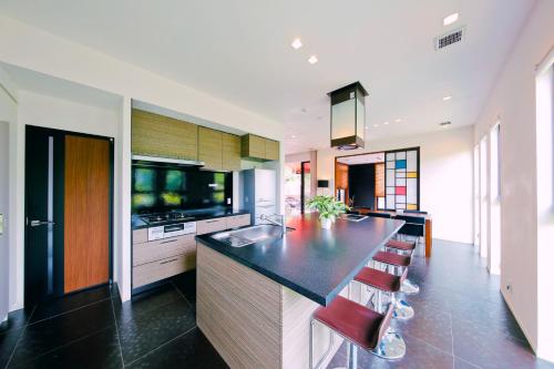 a kitchen with a counter and stools in a room at Danro no Yado Concept House Hoshida in Katano