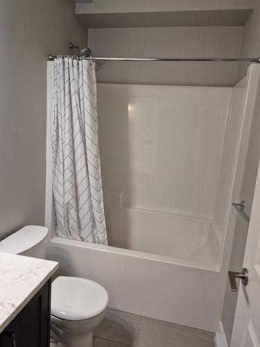a bathroom with a toilet and a bath tub at Spacious Private Suite Minutes Away from Ocean,Trails and Stores in Langford