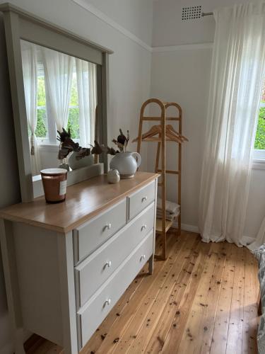 a dresser with a mirror on top of it at The Seaside Haven Umina in Umina