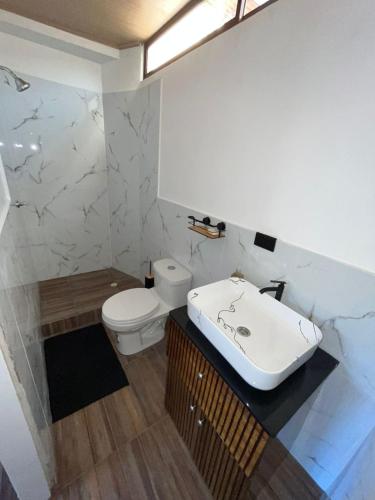 a bathroom with a white sink and a toilet at Casa playa crucita in Crucita