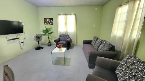 ein Wohnzimmer mit zwei Sofas und einem Flachbildfernseher in der Unterkunft Tranquil Escape in Arima