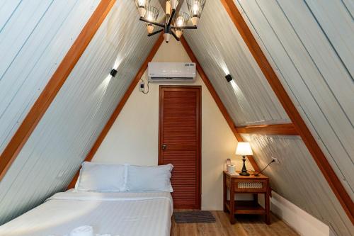 a bedroom with a bed in a attic at Paragos Silvina's Cabin 2 Resort Hotel in Maitim