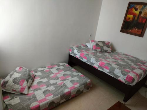 two beds sitting next to each other in a bedroom at Oasis Santafe in Santa Fe de Antioquia