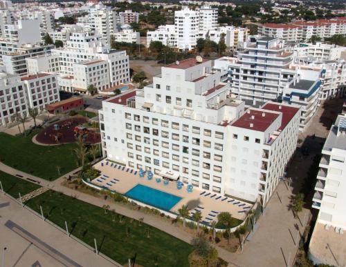 an aerial view of a large white building with a pool at Apartamentos Carteia in Quarteira
