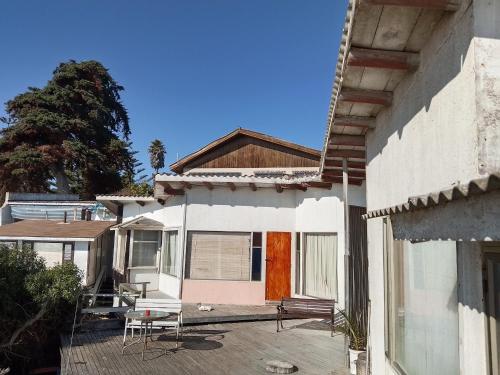 a house with a porch with a table and chairs at Cabañas mirasol in Algarrobo