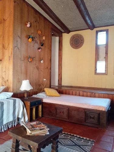 a room with two beds and a table in it at Cabañas mirasol in Algarrobo