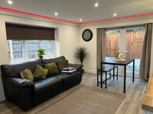 a living room with a black couch and a table at The Annex EV 10 per night in Southport