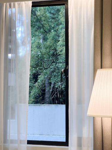 a window with a view of a tree at Casa De Baguio in Town Center in Baguio