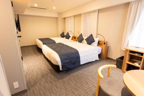 a hotel room with two beds and a table at Marroad Inn Akasaka in Tokyo