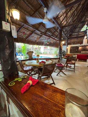 a bar with a table and chairs in a restaurant at Cocos Cabañas Playa del Carmen Adults Only in Playa del Carmen