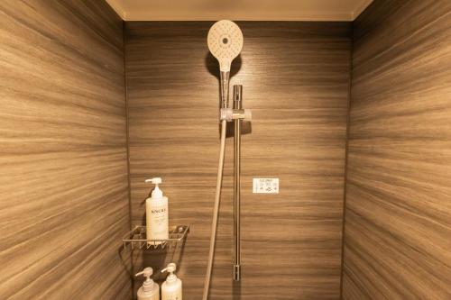 a shower with a shower head in a bathroom at Marroad Inn Akasaka in Tokyo