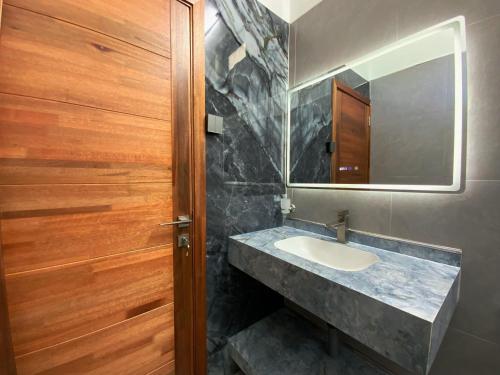 a bathroom with a sink and a mirror at Villa Oleemun Rezabeen - Mont Choisy in Mont Choisy