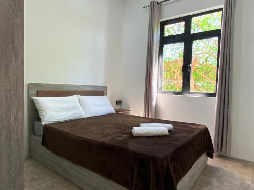 a bedroom with a bed with two towels on it at Villa Oleemun Rezabeen - Mont Choisy in Mont Choisy