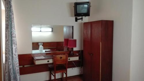 a bathroom with a sink and a mirror and a tv at Residencial Sol in Portimão