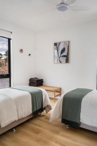 a white room with two beds and a table at Monapilla Escape in McLaren Vale