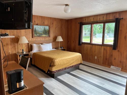 a hotel room with a bed and a television at Amber's Inn and Suites in Wisconsin Dells