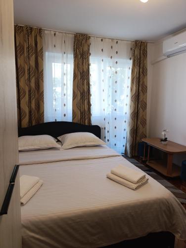 a bedroom with a large bed with two towels on it at Mim's Home in Băile Herculane