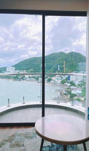 a window with a table and a view of the water at Khác Sạn Oytes Bay in Xa Thang Nhi